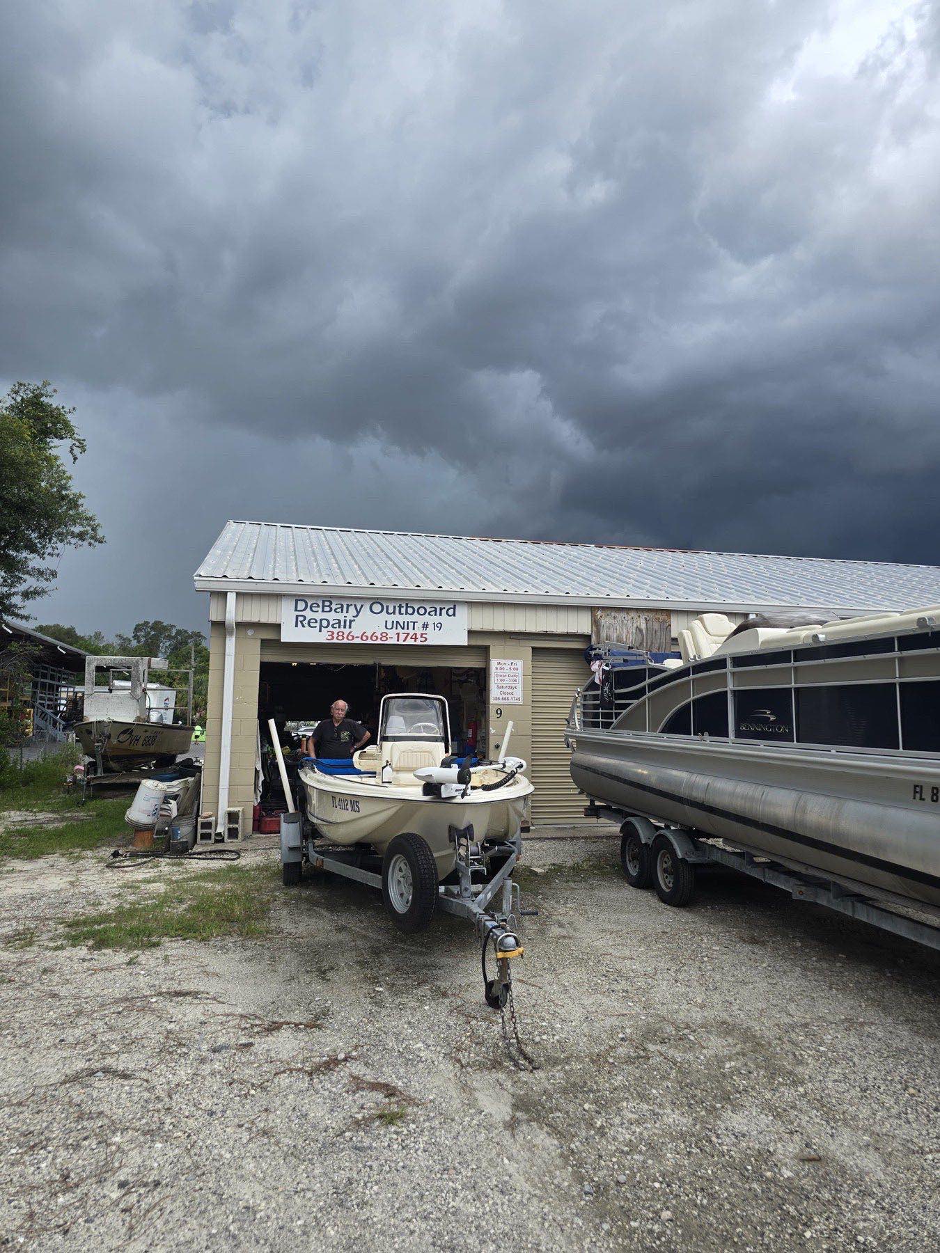 Boat on a trailer outside the DeBary Outboard Repair shop lot